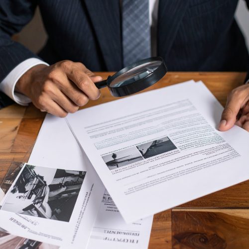 Firefly Un homme en costume qui étudie des documents et des photos sur une table avec une loupe. Cad